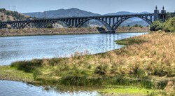 PHOTO BY BARRY EVANS - A 1932 seven-arch prestressed concrete bridge takes Highway 101 across the Rogue River at Gold Beach, ORE. Each arch spans 230 feet.