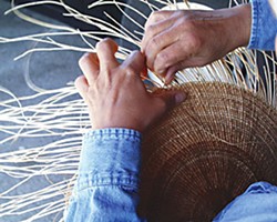 A Hoopa/Yurok weaver makes an acorn cooking basket from hazel sticks and spruce roots (which swell when wet to make a waterproof basket for cooking). Photo by Jennifer Kalt