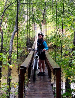 PHOTO BY JON O'CONNOR - Amy Cirincione, beginning her ride at a suspension bridge that crosses the Trinity River.
