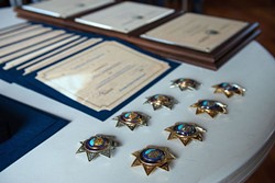 PHOTO BY MARK MCKENNA - Badges for new and promoted Eureka Police Department officers sit ready or pinning on a table at the Wharfinger on Wednesday.