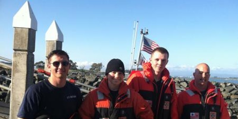 Coast Guard Station Humboldt Bay rescue crew members, from left, Seaman Noah Perry, Petty Officer 2nd Class Torre Taylor, Seaman Jacob Roberds, and Petty Officer 2nd Class Louis Ciccoli, pause for a photo after saving two fishermen from the surf after a wave overturned their boat.