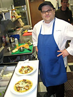 F St. Cafe Chef Dan McHugh puts finishing touch on seared scallop entrees. Photo by Bob Doran.