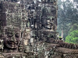 PHOTO BY BARRY EVANS - Four of more than 200 massive stone faces, perhaps in the likeness of the king who commissioned them, atop the Bayon temple in the Angkor Wat complex, Cambodia.