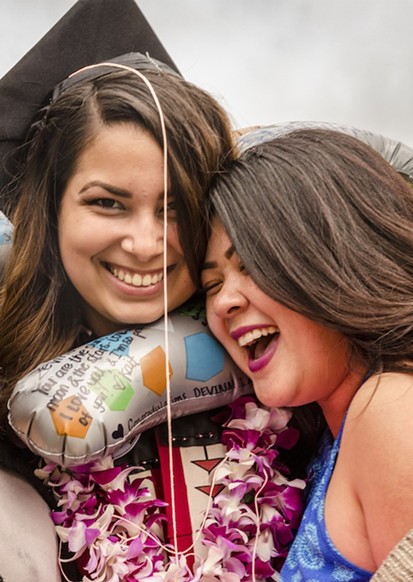 Kaitlyn Antonio, of Riverside, shared a burst of aerosal string and then a hug with her former room-mate Devina Miller, sociology major, after the ceremony.. - MARK LARSON