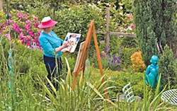 Lynne Wells painting in her garden. Photo courtesy of Redwood Art Association.