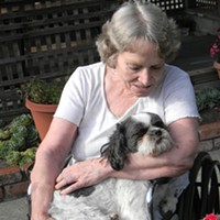 Marcia Murray cuddles Wicket, a nurse’s dog, in an outdoor patio at Eureka Rehabilitation & Wellness Center.