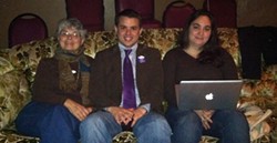PHOTO BY SCOTTIE LEE MEYERS - Newly elected city council member Shane Brinton cozies up next to his Mom, Susan Brinton (left), and Kaitlin Sopoci-Belknap to watch election results trickle in.