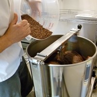 Pouring cacao nibs into mill