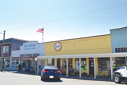 PHOTO BY HEIDI WALTERS - The throbbing heart of Main Street, Loleta, these days is that yellow building. It harbors a popular bakery and an 81-year-old meat market/town hub. To either side of it lie the post office and a busy little grocery store.