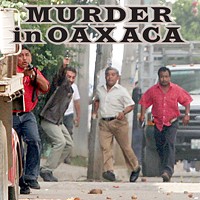 This photo, taken just as Brad Will was killed, shows clearly identifiable Oaxaca police officers firing at the crowd. See end of story for more details.