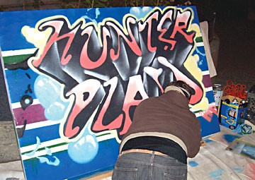 Tommy Warsaw spray-paints a sign for an Arts! Arcata opening. Photo by Jeff Hunter