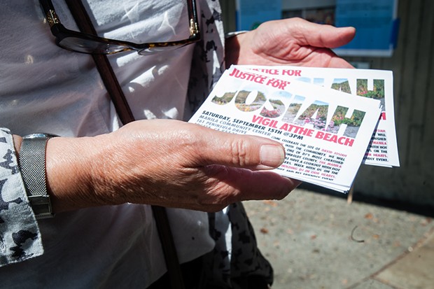 Meg Stofsky holds handbills for a Justice for Josiah vigil happening this weekend at the Manila Community Center. - PHOTO BY MARK MCKENNA