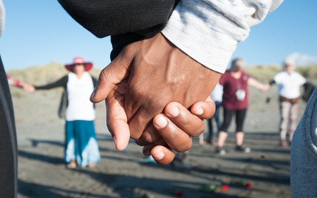 Vigil attendees joined hands in a circle to remember David Josiah Lawson. - MARK MCKENNA