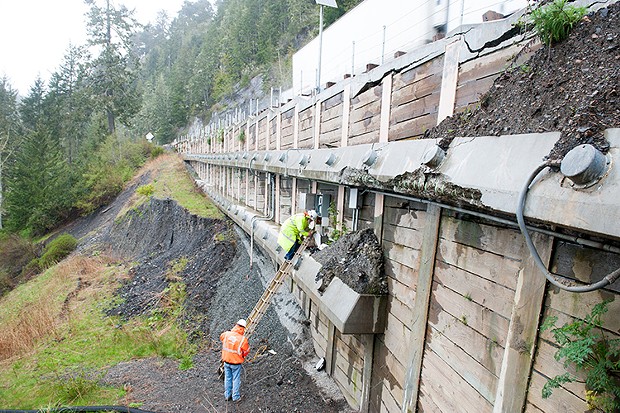 Workers gather data from load sensors on a retaining wall at one of the fail points. - PHOTO BY MARK MCKENNA