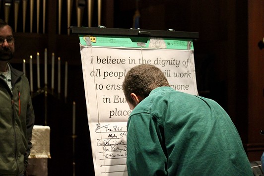 An attendee signs onto the pledge stating "I believe in the dignity of all people and I will work to ensure that everyone in Eureka has a safe place to call home." - FREDDY BREWSTER