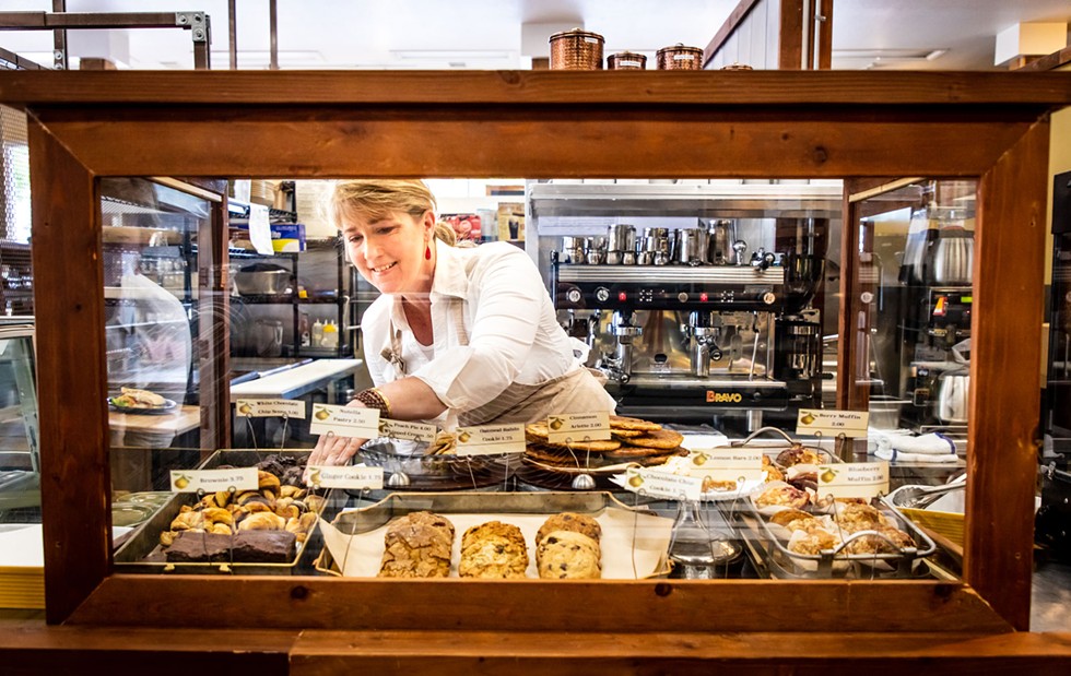 Owner Christine Silver fills the bakery case with treats. - AMY KUMLER
