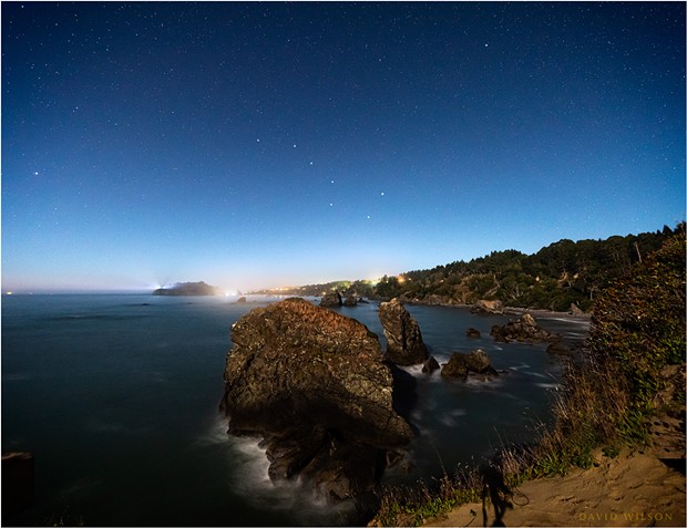 At the western edge of the North American continent, on the rough shores of the great Pacific Ocean, Trinidad, Humboldt County, California, sparkles in the moonlight under a starry sky. The Big Dipper and Polaris, the North Star, have been enhanced for recognizability. - DAVID WILSON
