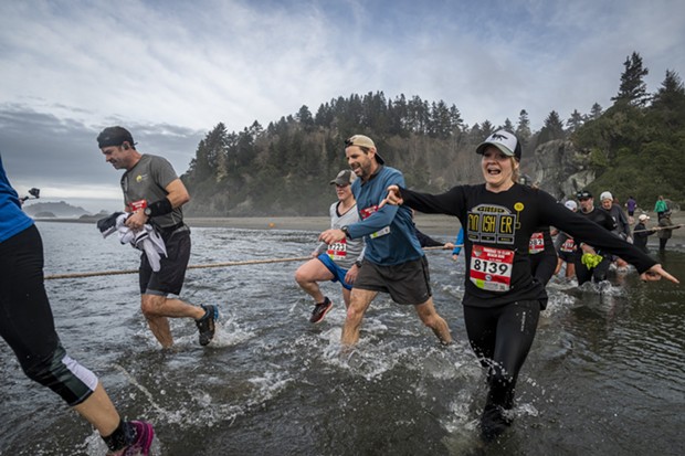 Andrea Carby, of McKinleyville, and a crowd of runners splashed their way across Little River. - MARK LARSON
