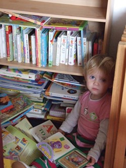 A child snuggles into her reading corner during child care. - PHOTO BY CAROL HARRISON