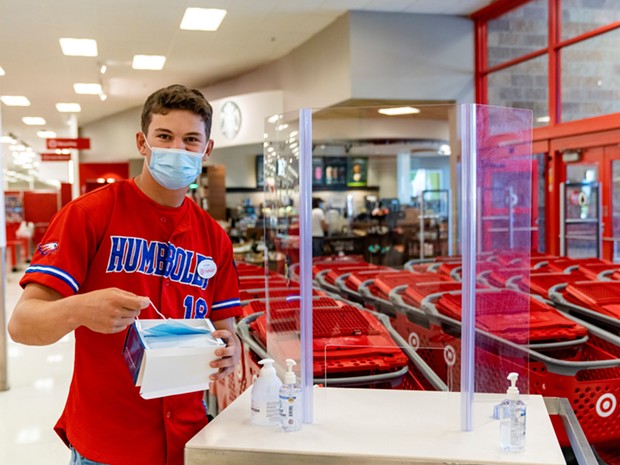 Target employee and Eureka High School senior Hayden Bode provides masks and hand sanitizer for shoppers who do not have one at no cost. - ZACH LATHOURIS