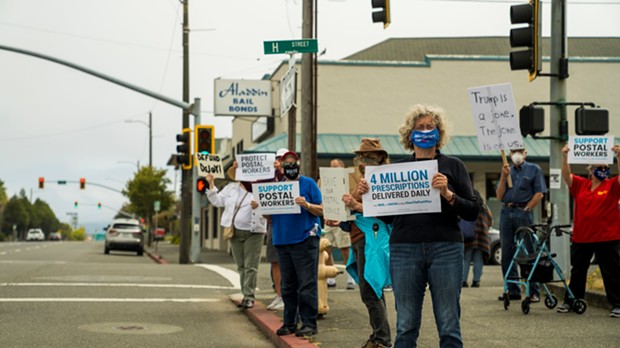 Demonstrators in Eureka display signs at a "Save the Post Office Saturday" rally. - ZACH LATHOURIS