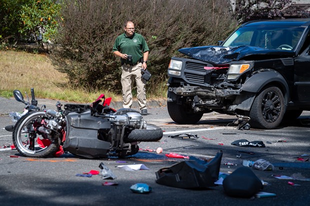 Deputy Coroner Chad Zeck documents the scene of a fatal head-on collision between a scooter and an SUV on the 5300 block of Walnut Drive. - MARK MCKENNA