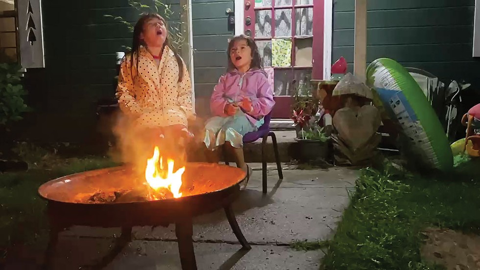 Right: Alexis Wickizer (left) and her sister Shelby howl by the fire in support of healthcare workers and first responders - PHOTO BY ASHLEY HARRELL
