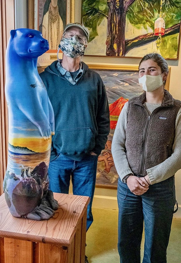 Jeff Black and Michelle Kunst standing by Maureen McGarrys North Coast Otter sculture at the Simmons Gallery. - TRINIDAD COASTAL LAND TRUST