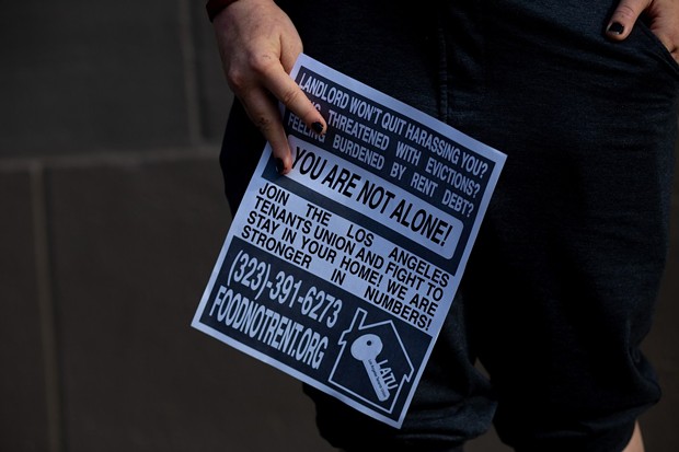 Jordan holds a rent strike poster that they made on May 6, 2021. - PHOTO BY SHAE HAMMOND FOR CALMATTERS