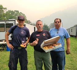 A fire crew from San Luis Obispo Fire Department enjoys a donut from Happy Donuts, delivered by Pay it Forward Humboldt, while responding to the Six Rivers Lightning Complex. - PAY IT FORWARD HUMBOLDT/FACEBOOK