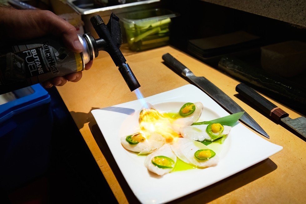 Talbert sears the Butterfish Carpaccio with a torch before adding sweetie drop peppers to finish the dish - PHOTO BY MARK MCKENNA
