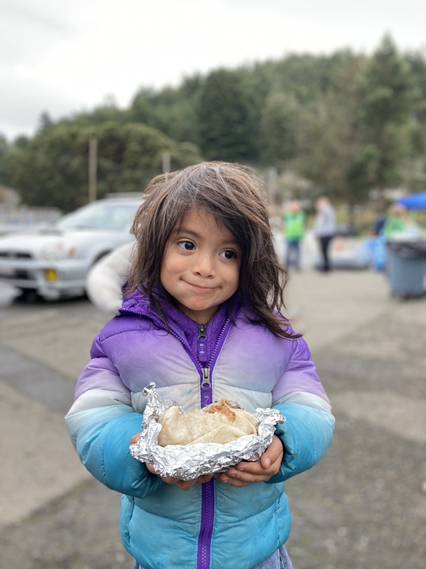 Three-year-old Leilani Valverde has a burrito sponsored by World Central Kitchen in Rio Dell. - PHOTO BY JENNIFER FUMIKO CAHILL