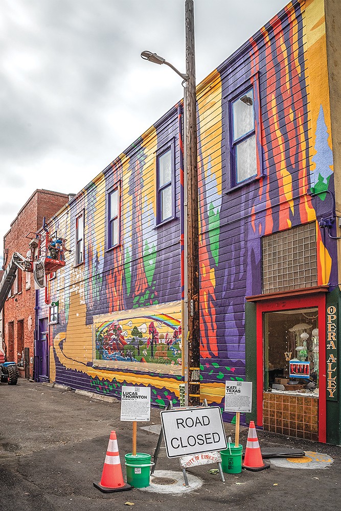 Mural artists Lucas Thorton and Kati Texas teamed up while painting on this side wall of Talisman Beads in Opera Alley in Old Town.  Thornton's  mural was his image of "Sequoia Sunrise" and Texas did a creative and careful re-working of an existing Larry Laitman landscape. - PHOTO BY MARK LARSON