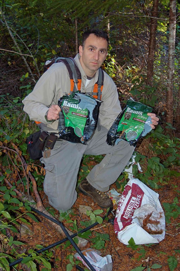 Mourad Gabriel poses with rodenticides found at a Supply Creek grow site in Humboldt County. - GRETA WENGERT/INTEGRAL ECOLOGY RESEARCH CENTER
