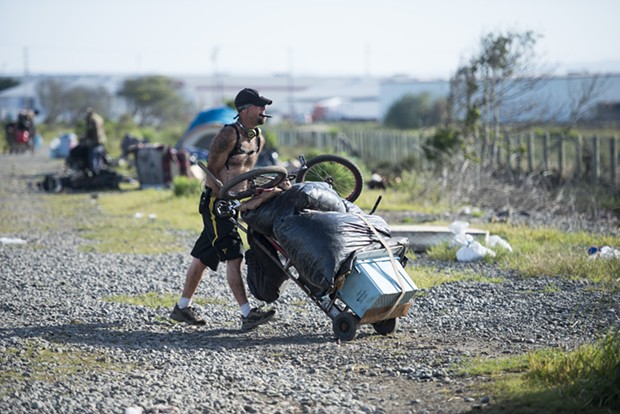 A homeless man moves out of the PalCo Marsh during the city's May 2 eviction. - FILE