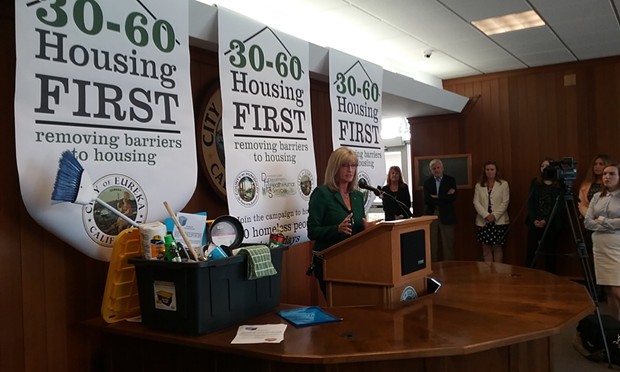 Supervisor Virginia Bass speaks at the launch of the city and county's Housing First campaign. The cleaning supplies were donated by a local outreach group as a "welcome home" gift to new renters. - LINDA STANSBERRY