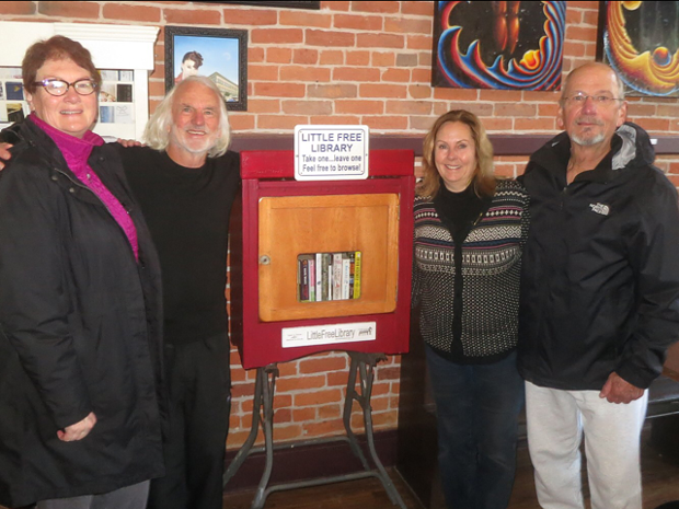 The Little Free Library in Old Town Coffee and Chocolates, started by Journal contributors Barry Evans and Louisa Rogers. From left to right: Rebecca Kalal, Barry Evans, Gail Mentink and Gil Yule. - SUBMITTED