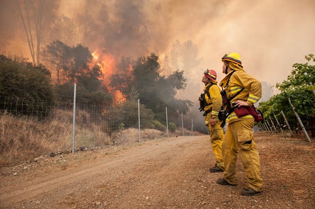 Chris Mitchell, left, and Arly Allen watch the progress of the fire as it slowly burns towards a private road on the Cache Creek Winery in Lake County. - MARK MCKENNA