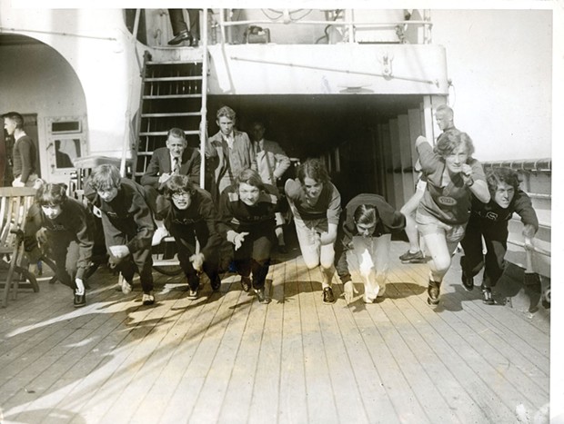 Women runners of the US Olympic team practicing on the high seas aboard the S.S. President Roosevelt in 1928. Left to Right: Elta Cartwright, Elizabeth Robinson, Ann Varana, Mary T. Washburn, Olive B. Hasenfun, Loretta McNeil and Edna E, Sayer. Coach Mel Sheppard is seated on the ladder.