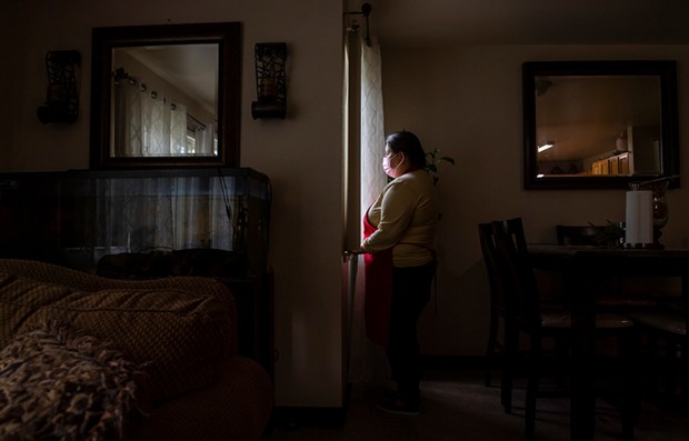 Blanca Esthela Trejo, 46, is photographed looking outside the windows near her dining room table inside her home in Salinas on April 22. Photo by David Rodriguez, The Salinas Californian
