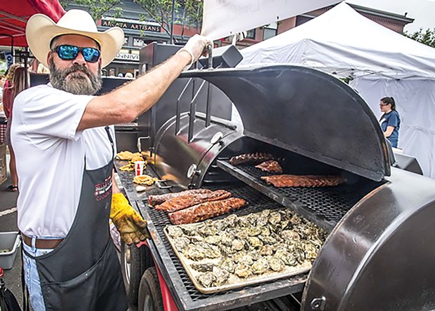 Cook Chris Barry grilling oysters on the plaza during the 2019 Arcata Bay Oyster Festival.