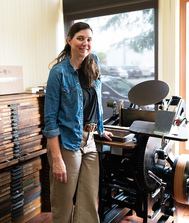 Lynn Jones with the 1925 Chandler &amp; Price platen press on which she cranks out packaging for Dick Taylor Craft Chocolate.