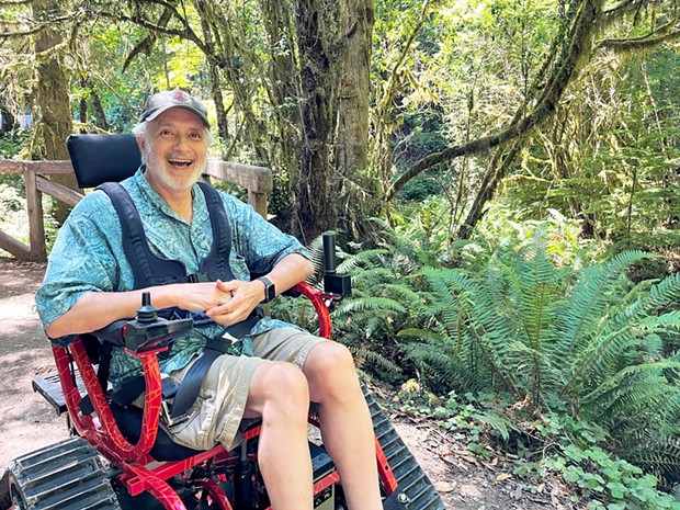 Visitor David Echt uses the track chair from David's Chair at Prairie Creek Redwoods State Park.