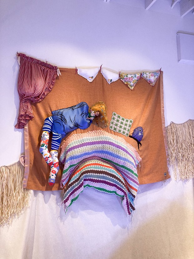 A doll sleeps in a fabric tableau in Nancy Tobin's CRy-Baby installation.