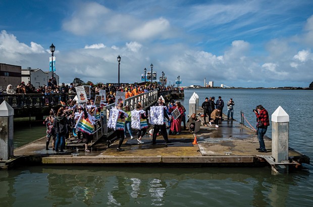 A large crowd gathered at the foot of F Street to watch Perilous Plunge participants, including the Redwood Capital Bank team marching down the ramp and onto the dock before entering Humboldt Bay.