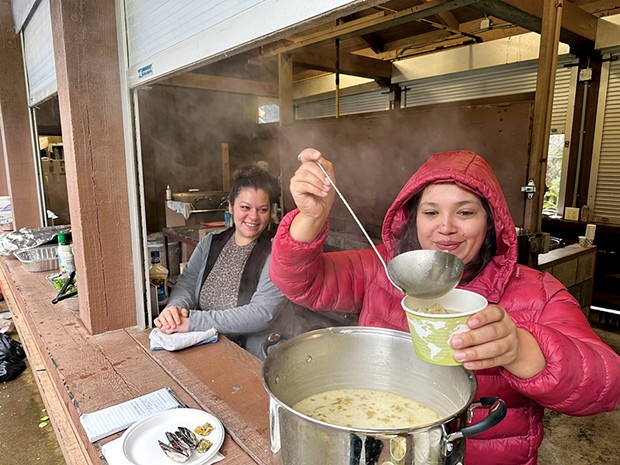 Dianna Beck looks on as Kayla Maulson serves chowder with traditionally harvested mussels.