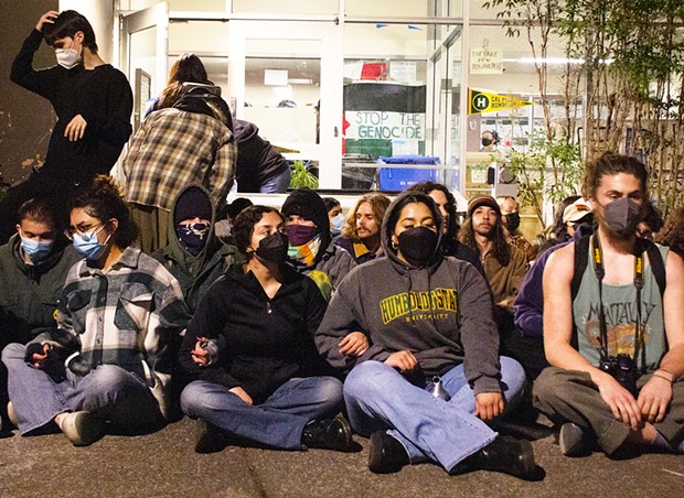 Protesters sit in front of Siemens Hall on April 22.