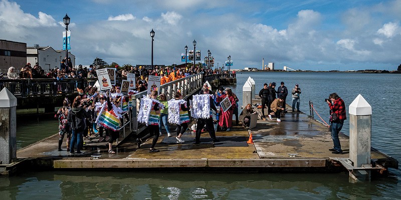 A large crowd gathered at the foot of F Street to watch Perilous Plunge participants, including the Redwood Capital Bank team marching down the ramp and onto the dock before entering Humboldt Bay.