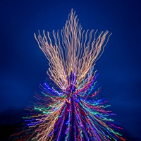 Woodley Island Walkabout Slideshow This is a special camera-exposure effect from zooming in or out while using a slow shutter speed while looking at the Commercial Fishermen's Wives' lighted "tree" made out of dozens of crab pots. The Christmas tree's star faces out towards Humboldt Bay to welcome home the fishing boats and crew. Photo by Mark A. Larson