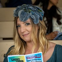 Ladies Hat Day 2024 Stephanie Souter of Eureka paused while perusing the Fair's official program in the grandstands; she also chose to simply dress for the occasion and not compete. Photo by Mark Larson